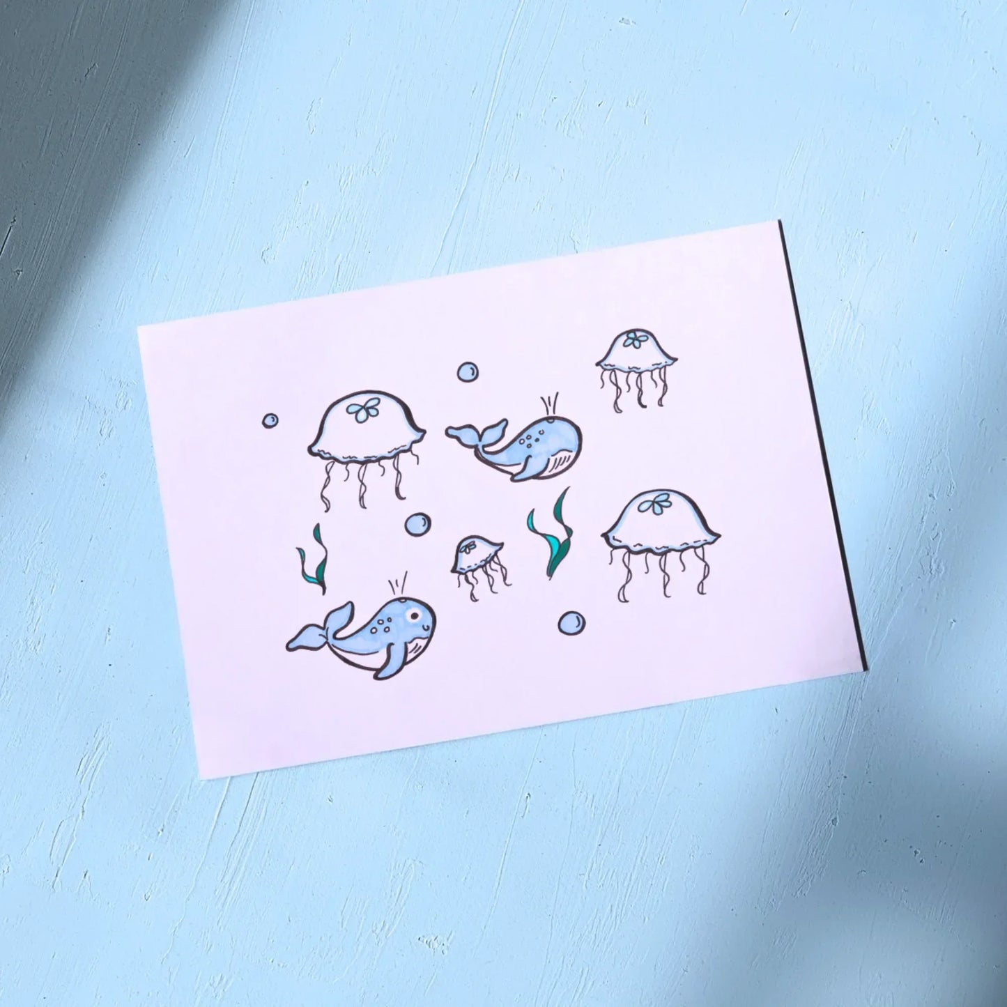 White Greeting Card with illustrations of whales and jellyfish on a light blue background