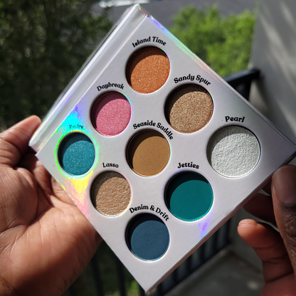 Makeup palette with various colors held by a hand, Seaside Lasso Eyeshadow palette