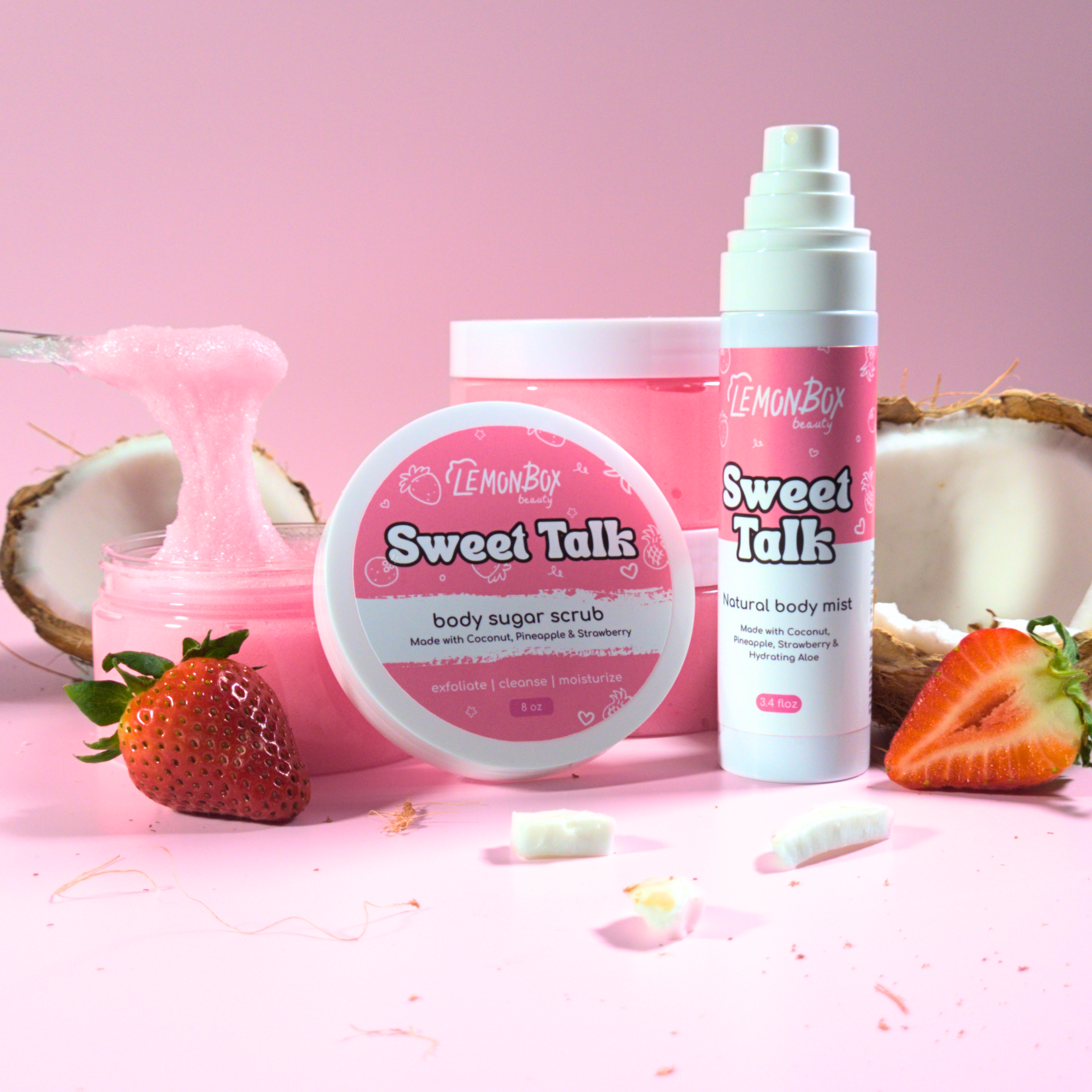 LemonBox Sweet Talk body products including a jar, spray bottle, and scrub on a pink background with strawberries and coconuts.