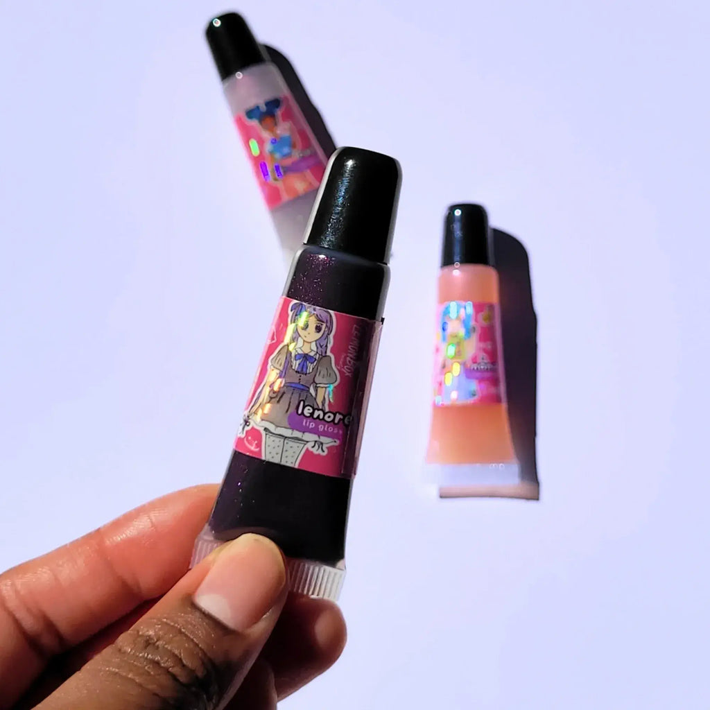 Lemon Box Beauty Lenore Anime Shine Lip Gloss - deep shimmering plum-purple vegan lip oil in a squeeze tube with custom dark coquette anime character artwork.