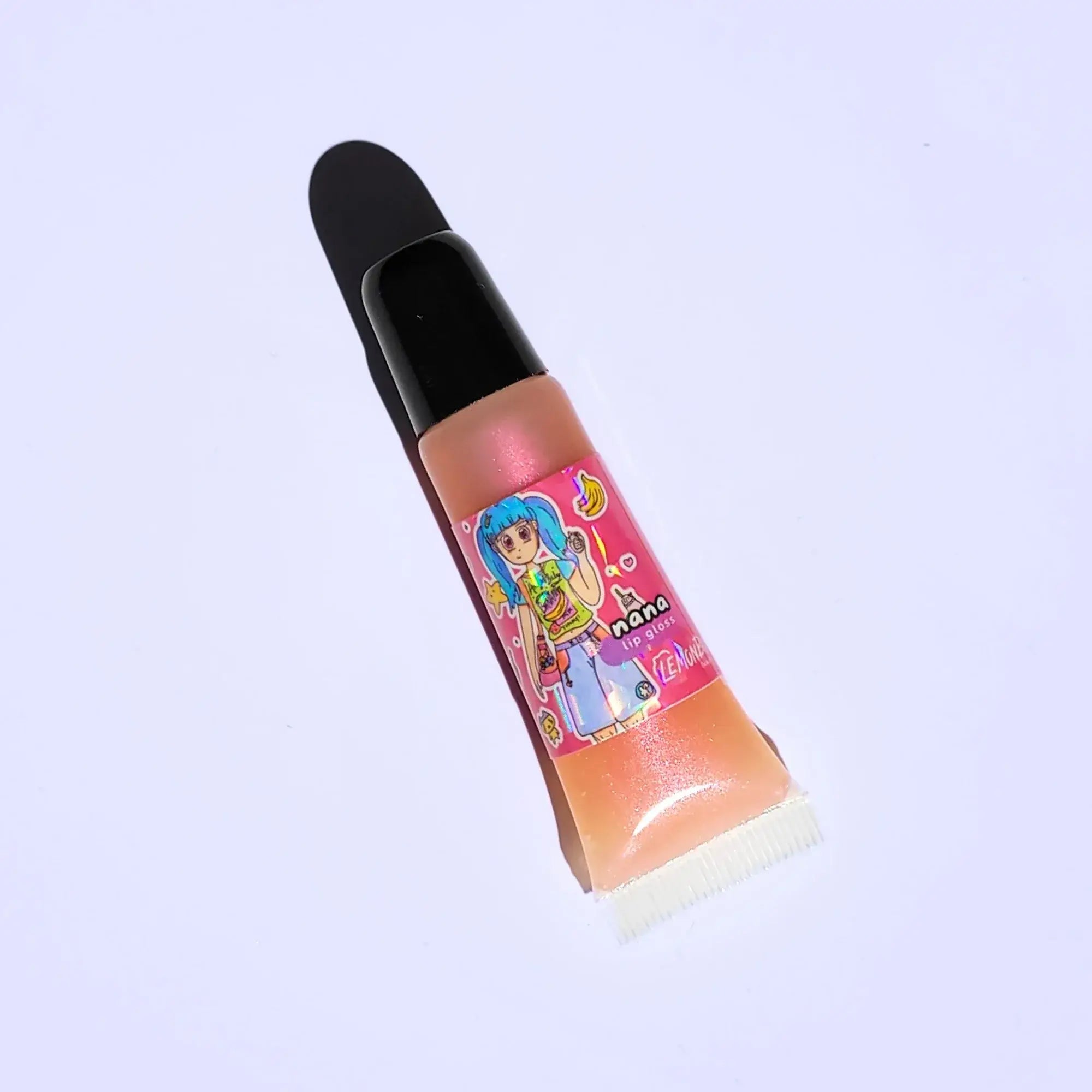 Lemon Box Beauty Nana Anime Shine Lip Gloss - shimmering peachy-pink vegan lip oil in a squeeze tube with custom Heisei retro anime character artwork.
