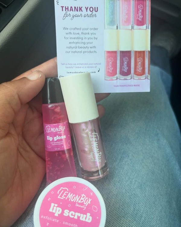 Lemon Box lip gloss and lip scrub with a thank you card in the background.