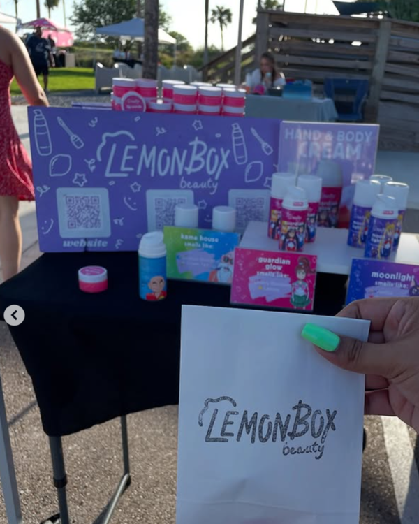 LemonBox beauty products displayed on a table outdoors with a person holding a LemonBox bag.
