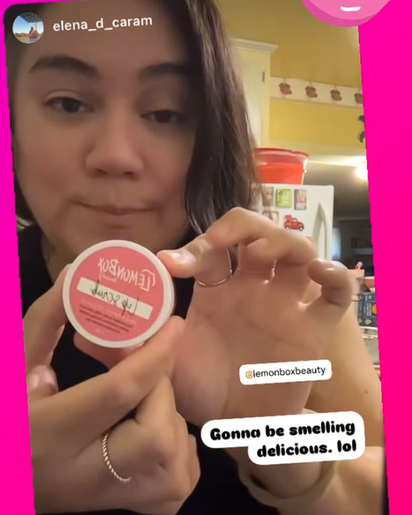 Person holding a container of Lemon Box Beauty Strawberry Coconut Lip Scrub product with a pink border and text overlay.