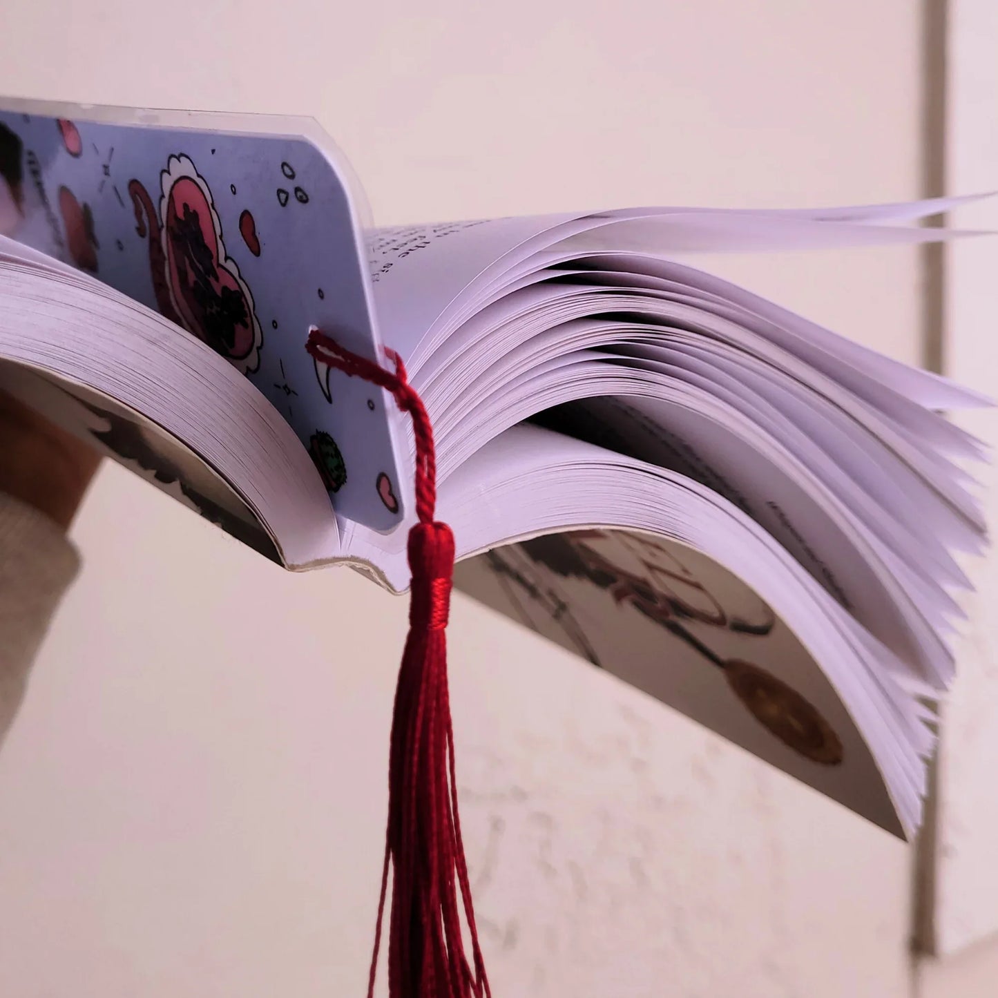 Open book with a red bookmark on a light background