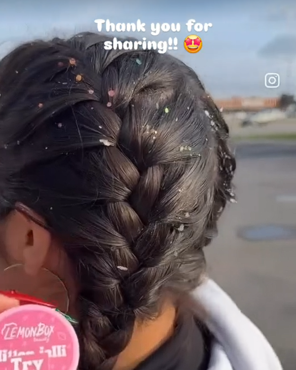 Person with braided hair holding a Glitter jelly makeup jar, with girl with glitter in hair on braids
