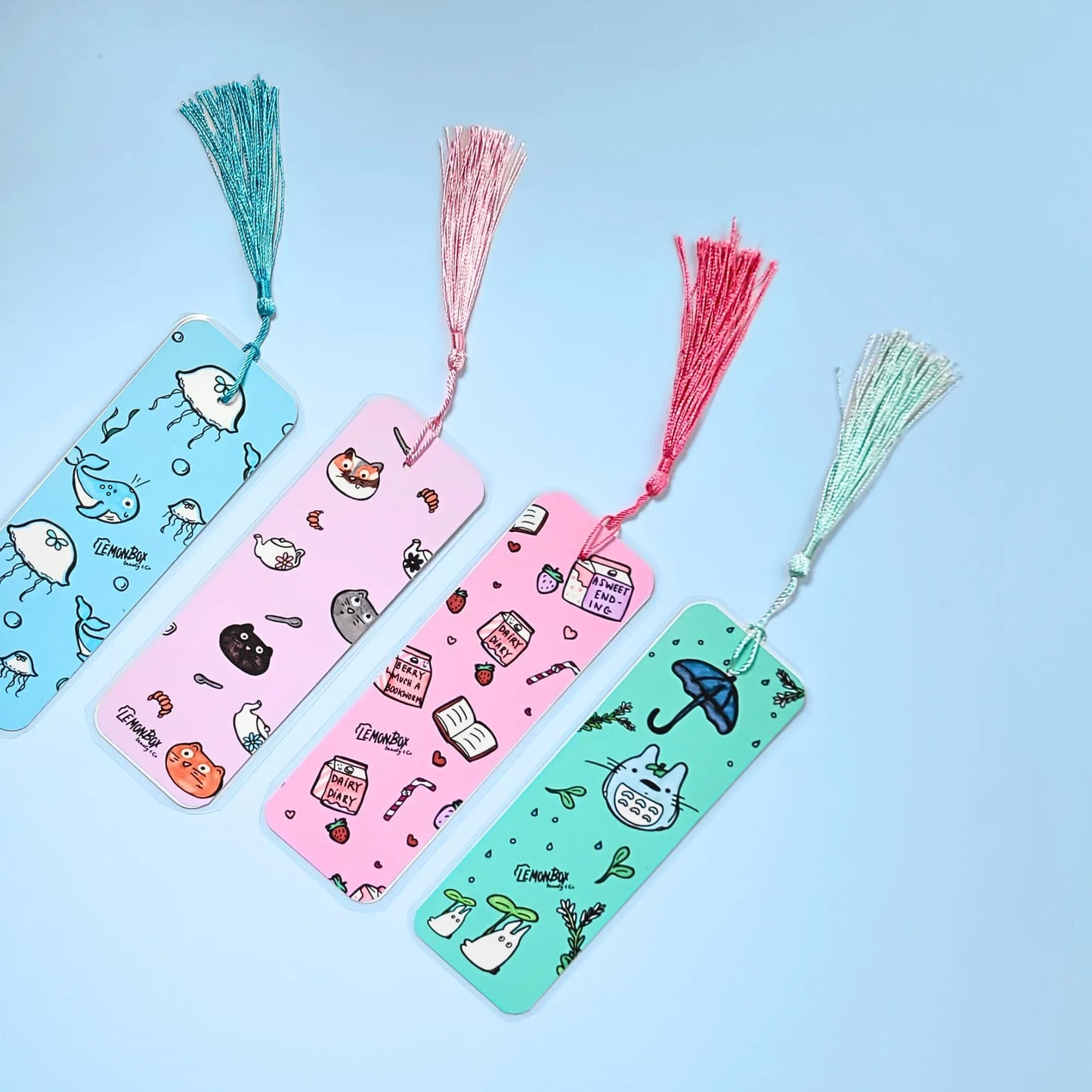 Four colorful bookmarks with tassels on a light blue background