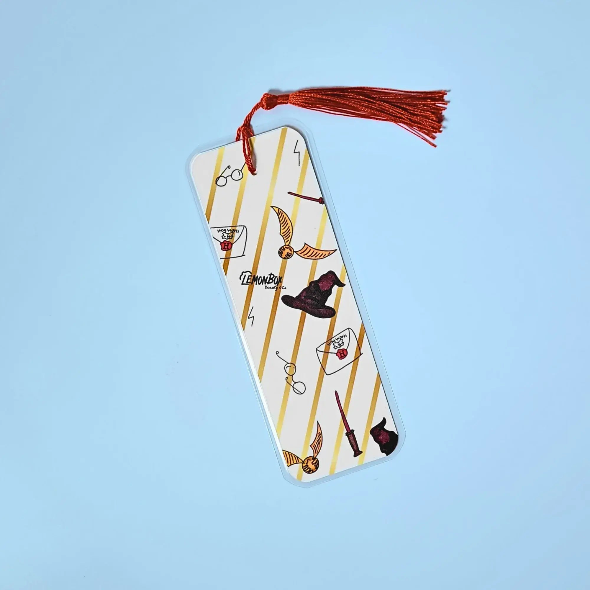 White and gold bookmark with illustrations from Harry Potter on a light blue background