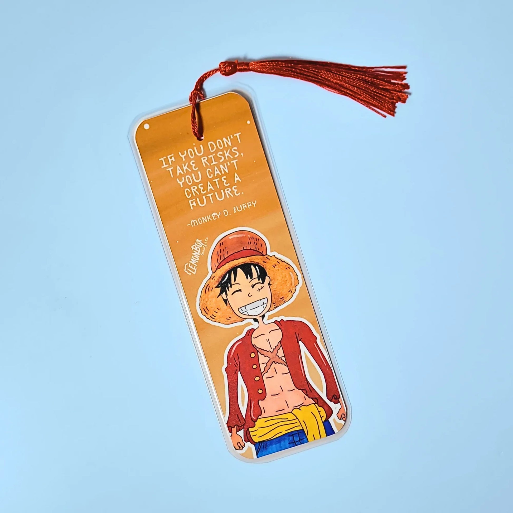 Orange bookmark with illustration of Luffy D. Monkey from One Piece and motivational quote on a light blue background