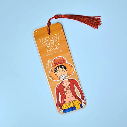 Orange bookmark with illustration of Luffy D. Monkey from One Piece and motivational quote on a light blue background