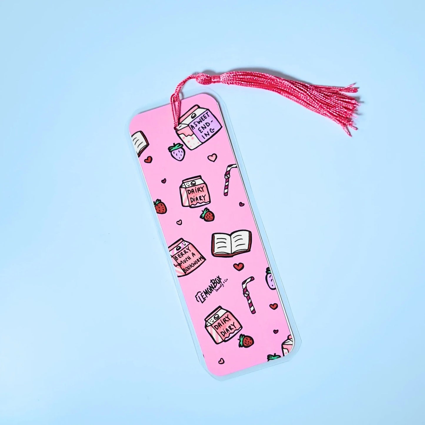 Pink bookmark with Strawberry Milk themed design on a light blue background