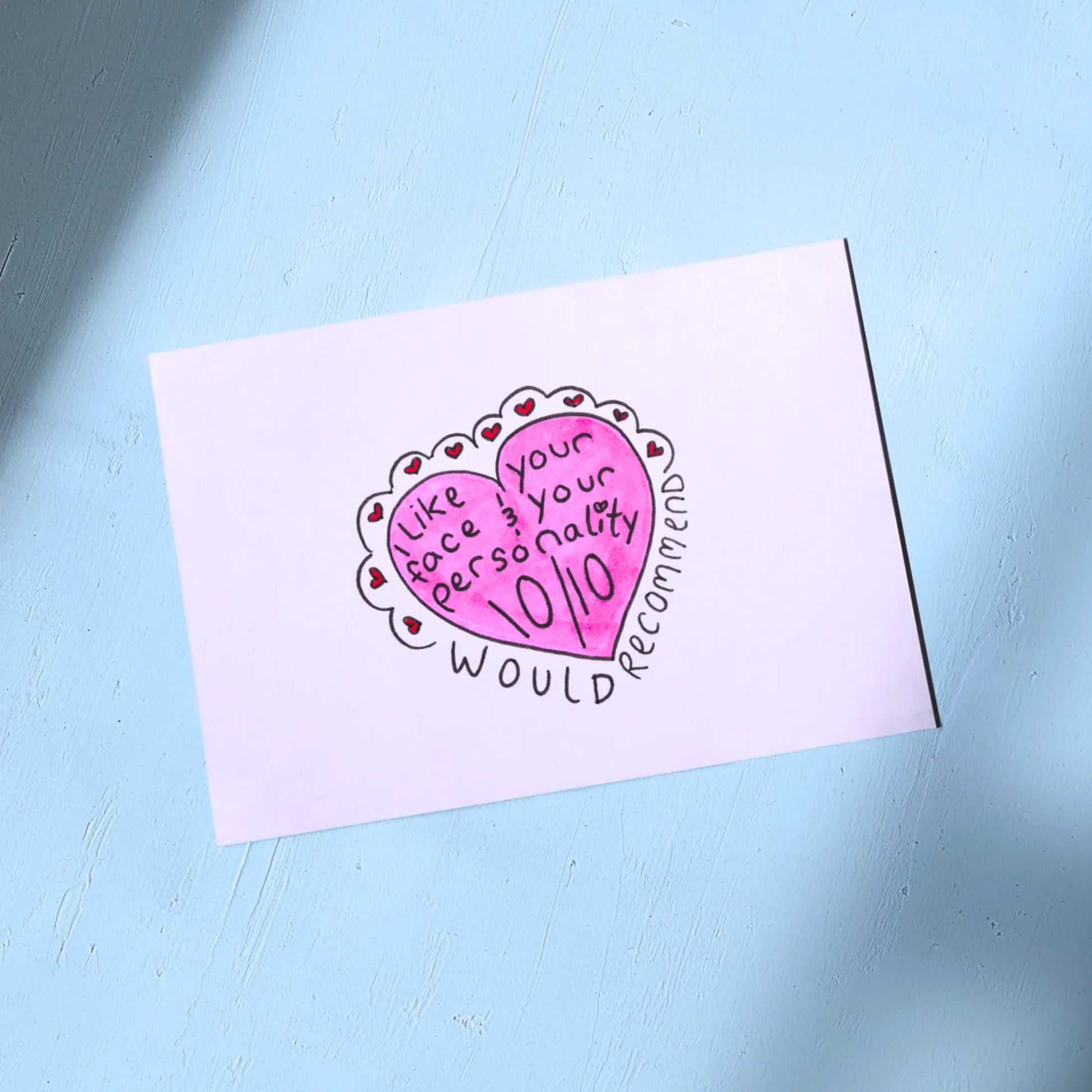White Greeting Card with Valentines Themed design on a light blue background