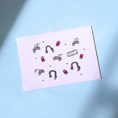 White Greeting Card with illustrations of gaming controllers and soda cans on a light blue background