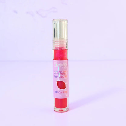 Lemon Box Beauty Grapeseed Vitamin E Lip Gloss in shade Melon Kiss - shimmering hot pink hydrating lip oil in a clear tube against a lavender background.
