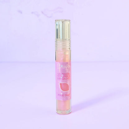 Lemon Box Beauty Grapeseed Vitamin E Lip Gloss in shade Pixie Dust - iridescent pale pink shimmering lip oil in a clear tube against a lavender background.