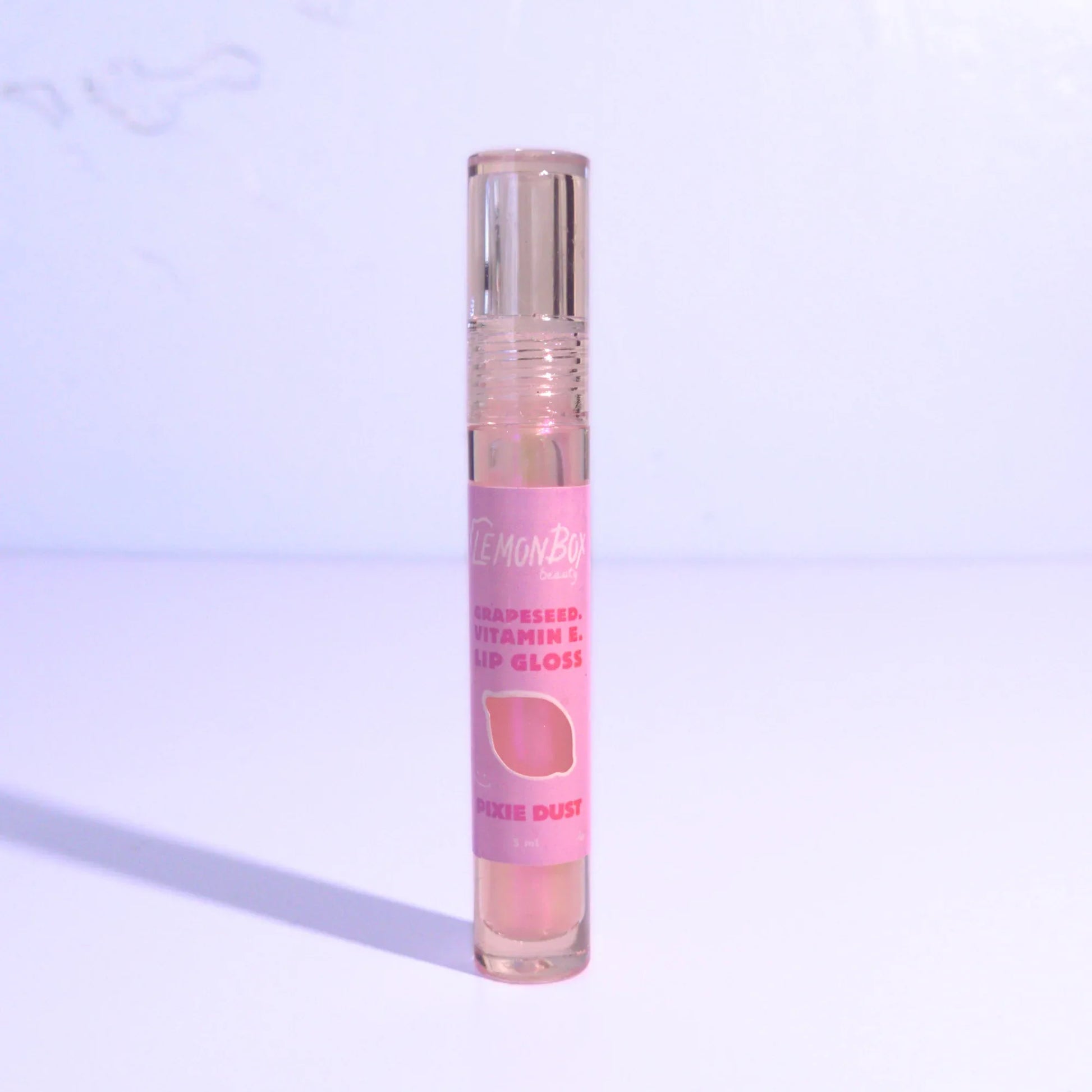 Iridescent lip gloss with a clear cap on a light purple background