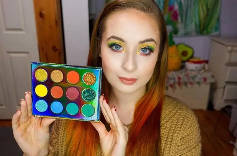 Woman holding a colorful makeup palette with a casual indoor background