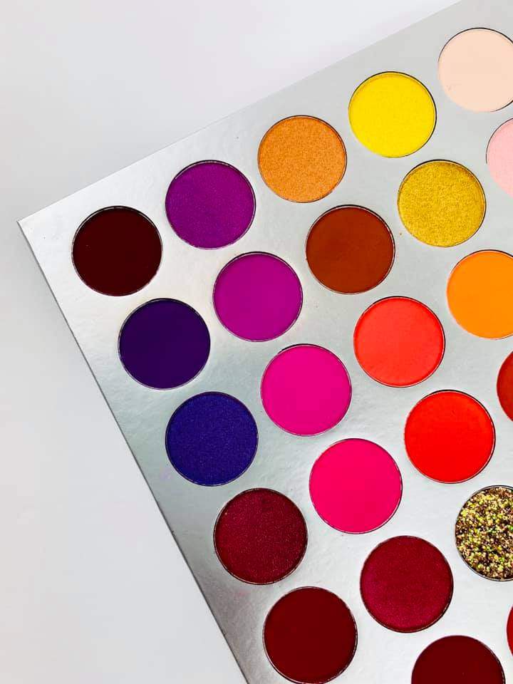 Colorful makeup palette with various shades on a light gray background