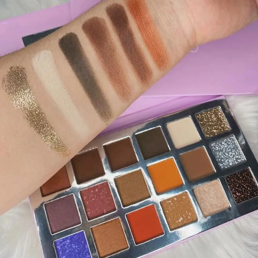 Makeup palette with swatches on a hand against a purple background Midnight