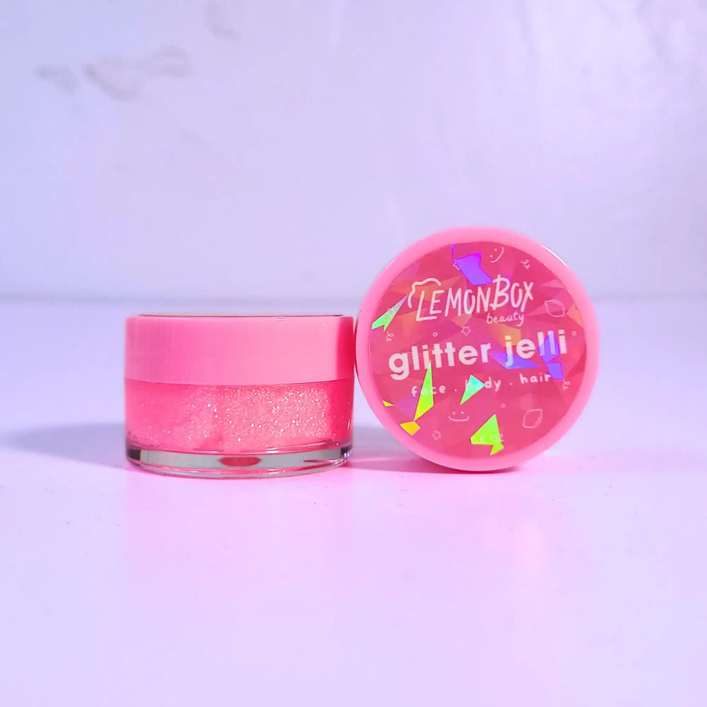 Pink glittery jar with 'Lemon Box Beauty' lid on a light purple background