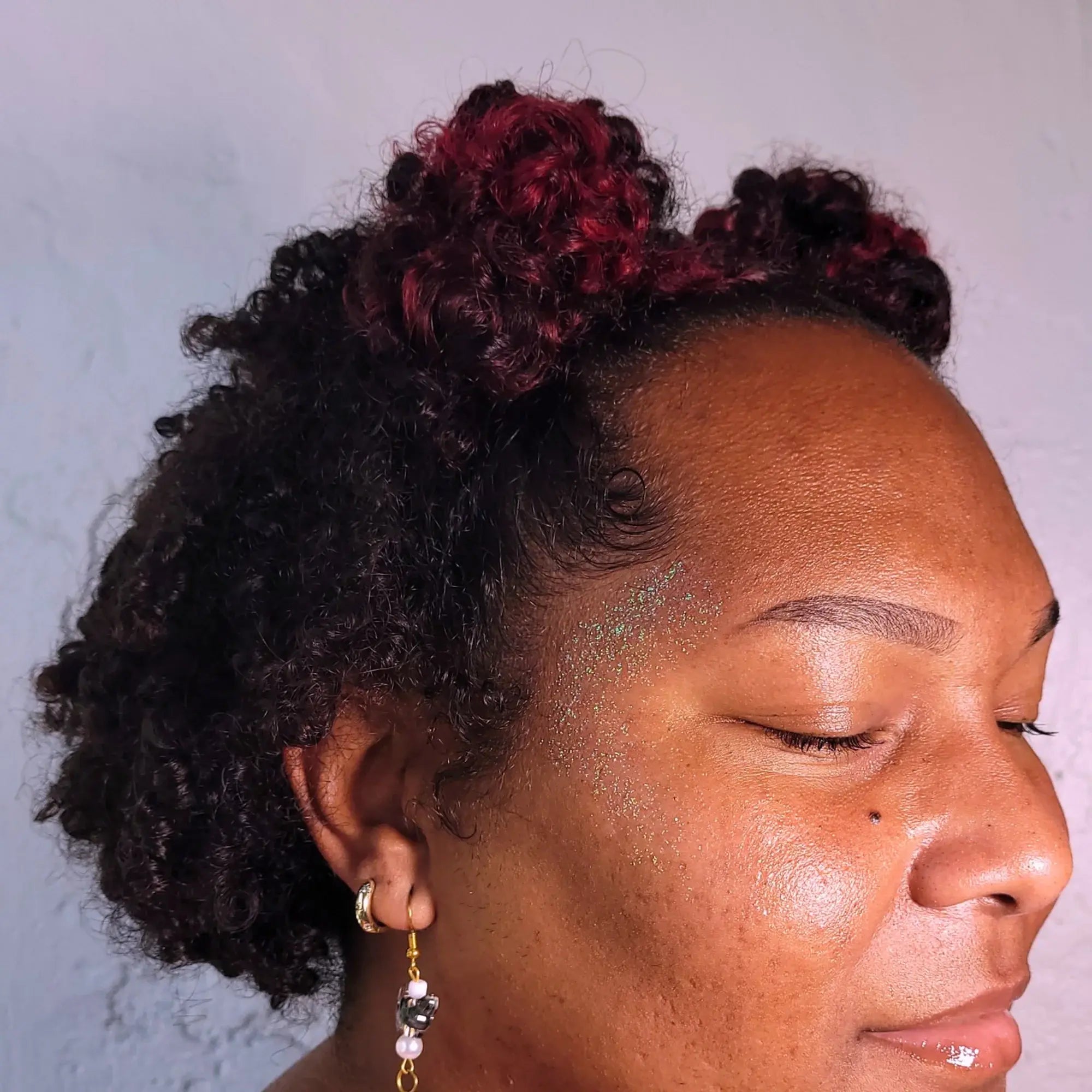Close-up of a person with styled hair against a neutral background