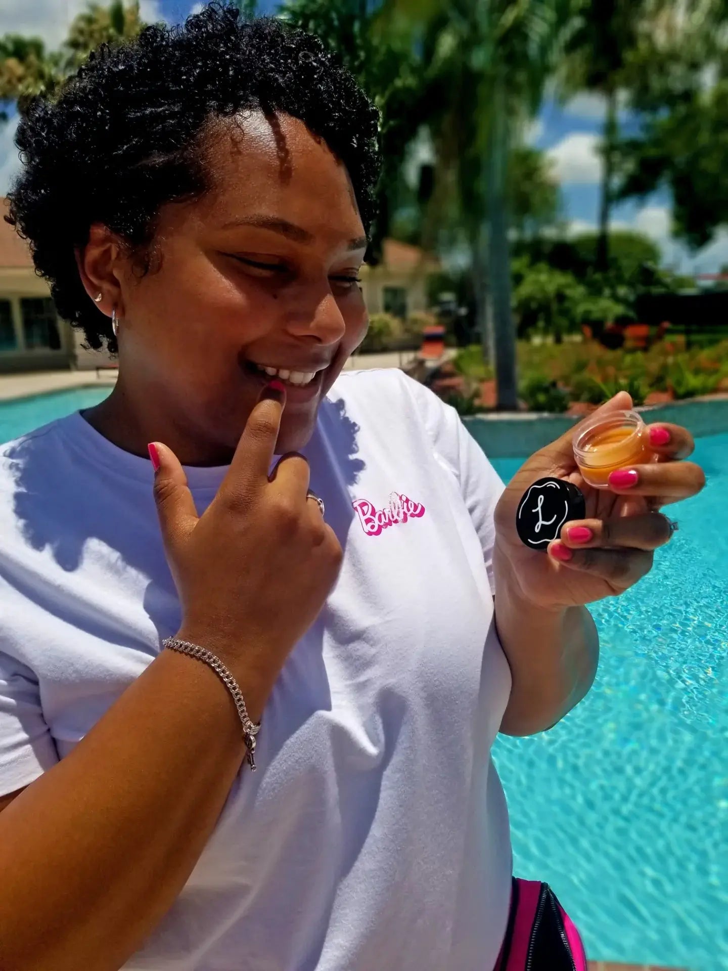 Person holding a small container by a pool