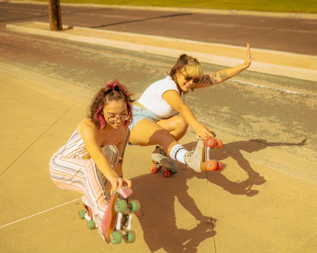 Two women roller skating on a sunny day