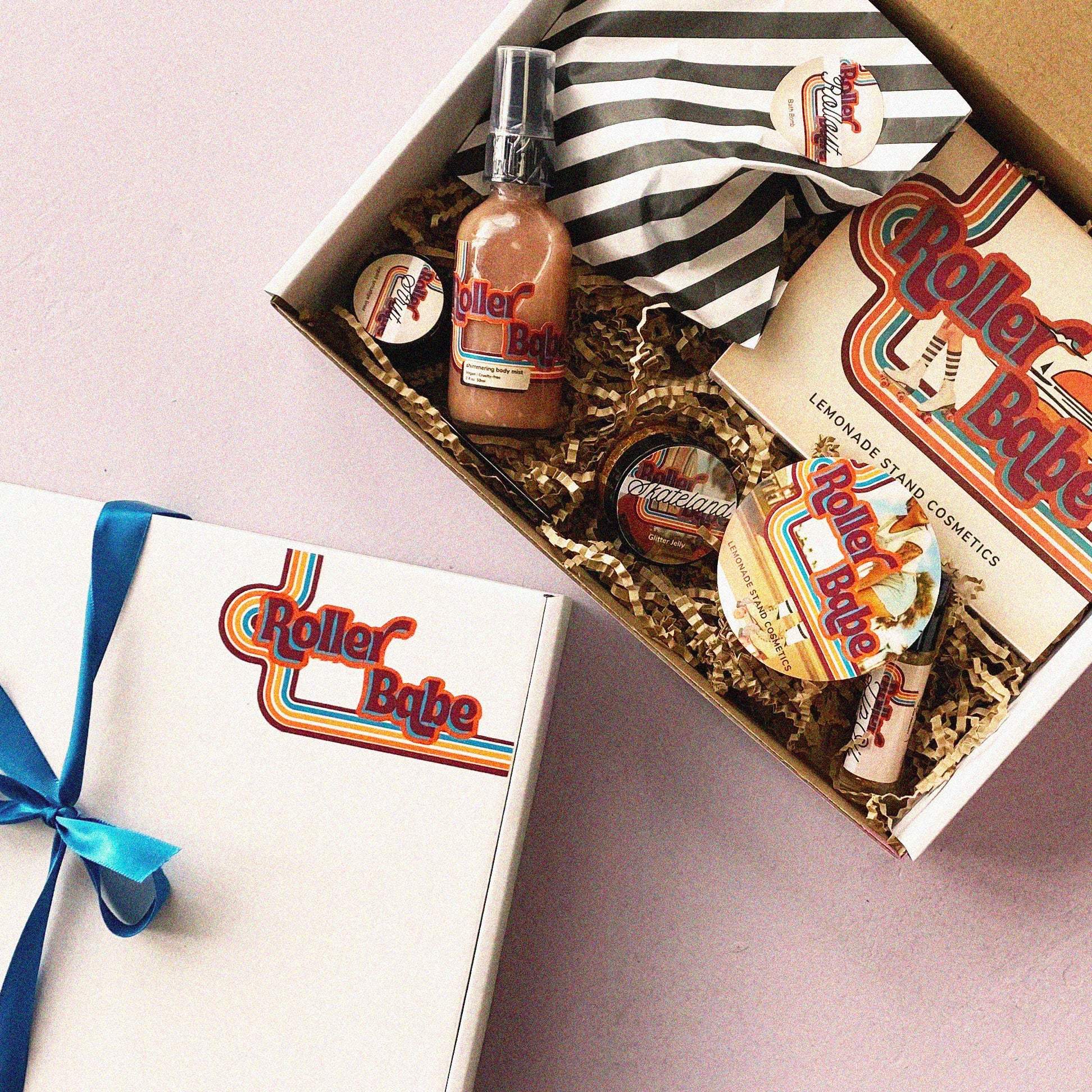 Gift box with 'Roller Babe' products on a light pink background