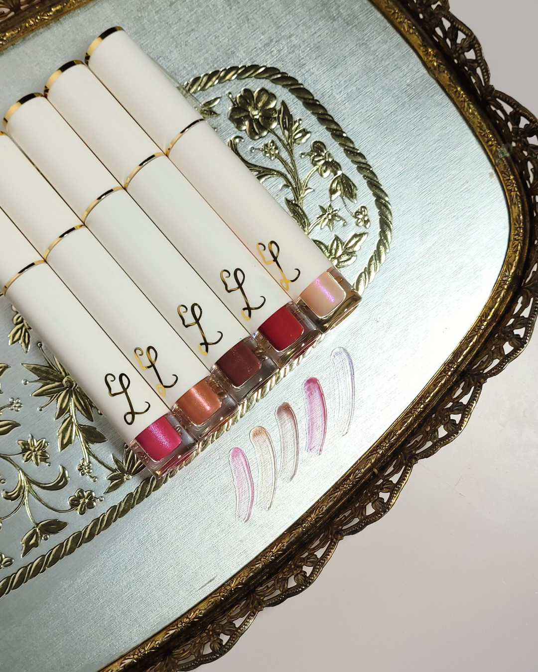 Set of lipsticks with visible color swatches on a decorative tray