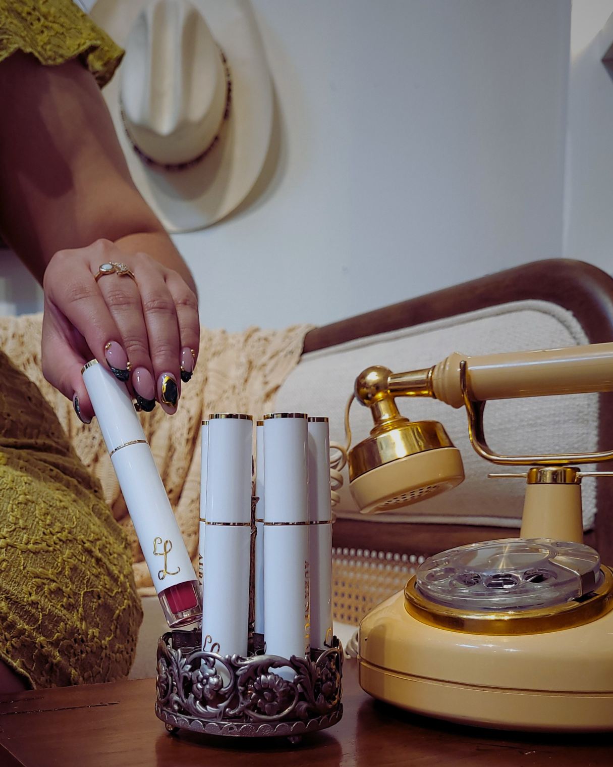 Vintage phone on a table with a hand holding a cigarette and multiple cigarettes in a holder.