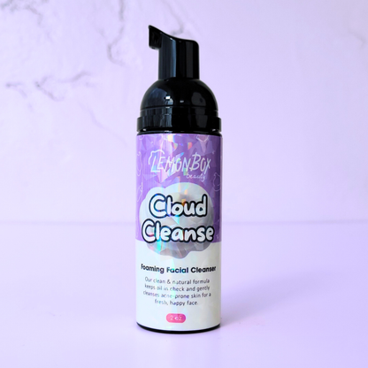 A 2 oz bottle of Cloud Cleanse Foaming Facial Cleanser with a black pump dispenser and holographic labeling, set against a soft lavender background.