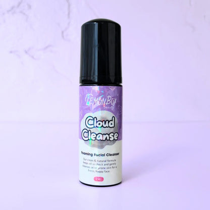 A 2 oz bottle of Cloud Cleanse Foaming Facial Cleanser with a black pump dispenser and holographic labeling, set against a soft lavender background.