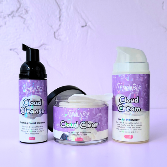 A professional product lineup featuring the Cloud Cleanse Foaming Cleanser, Cloud Clear Toning Facial Pads, and Cloud Cream Facial Moisturizer on a soft lavender background.