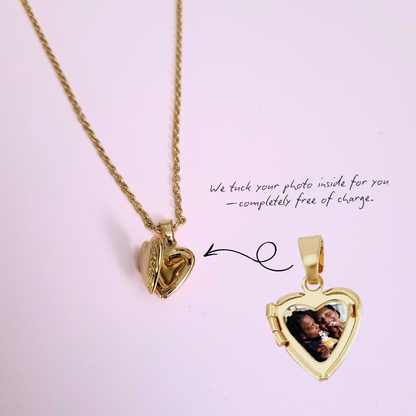 Gold heart-shaped locket with a photo inside on a pink background