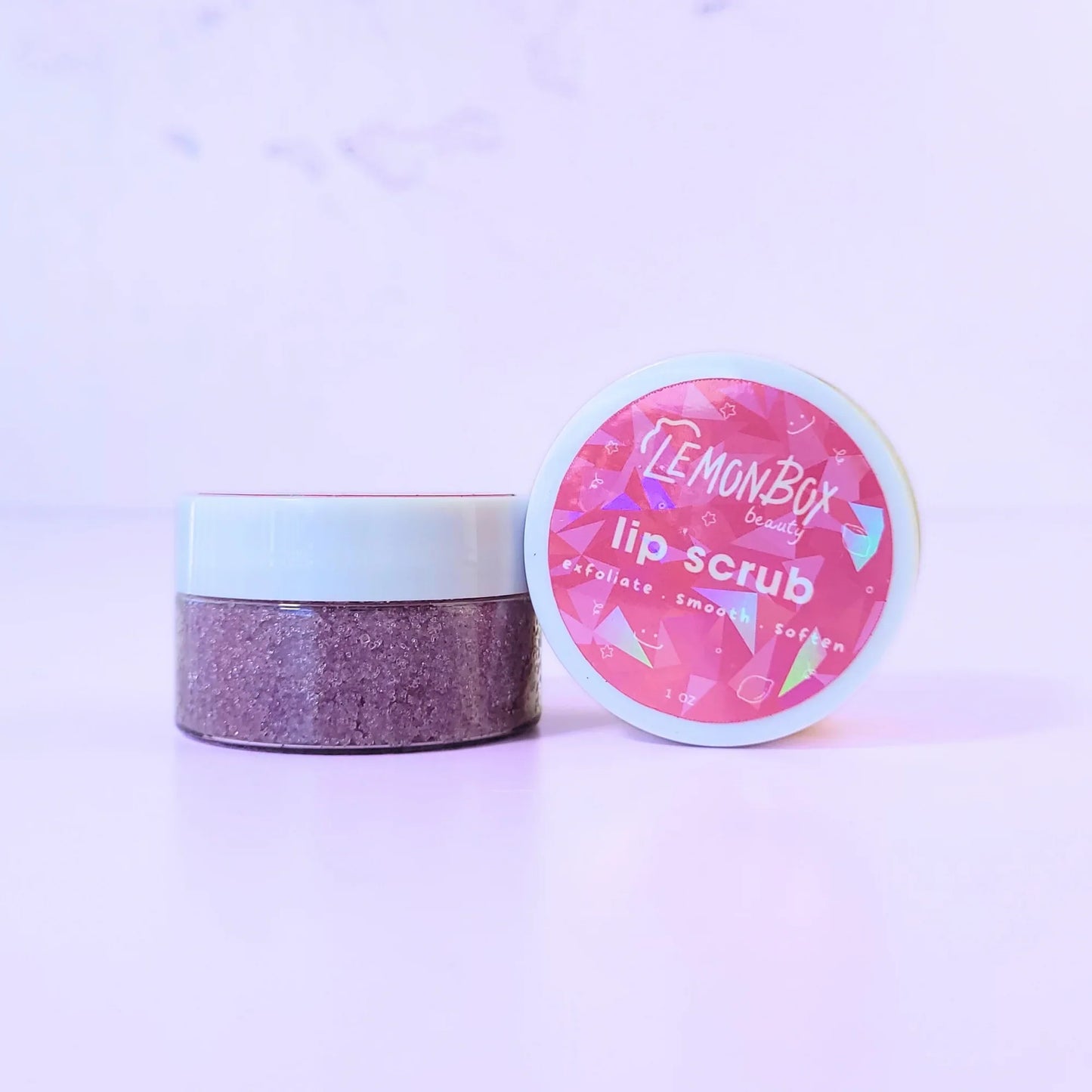 Lemon Box Beauty Vine Picked Blueberry Lip Scrub - 1oz jar of purple sugar scrub to exfoliate, smooth, and soften lips on a lavender background.