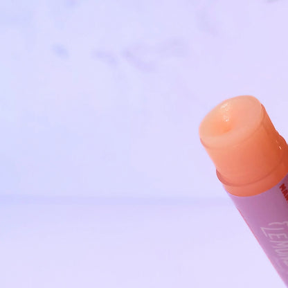 Lemon Box Beauty Cherry Lemon Lip Balm - Mango Butter and Vitamin E infused hydrating balm tube on a lavender background.