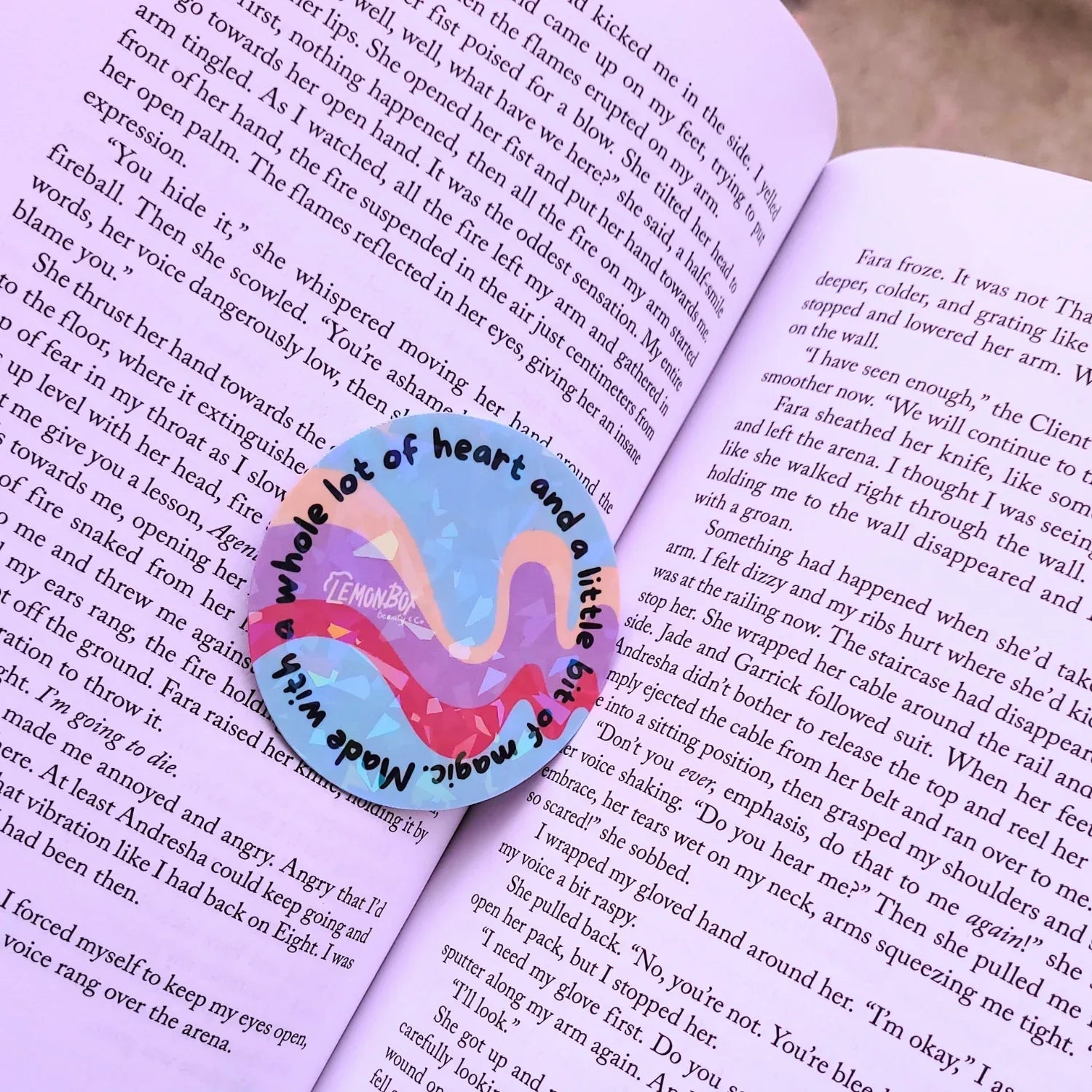 Flamingo-shaped bookmark with 'a whole lot of heart and a little bit of world' text on an open book.