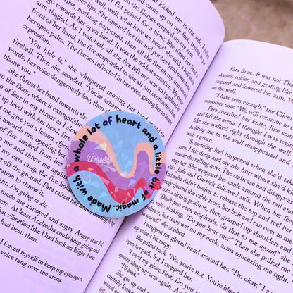 Flamingo-shaped bookmark with 'a whole lot of heart and a little bit of world' text on an open book.