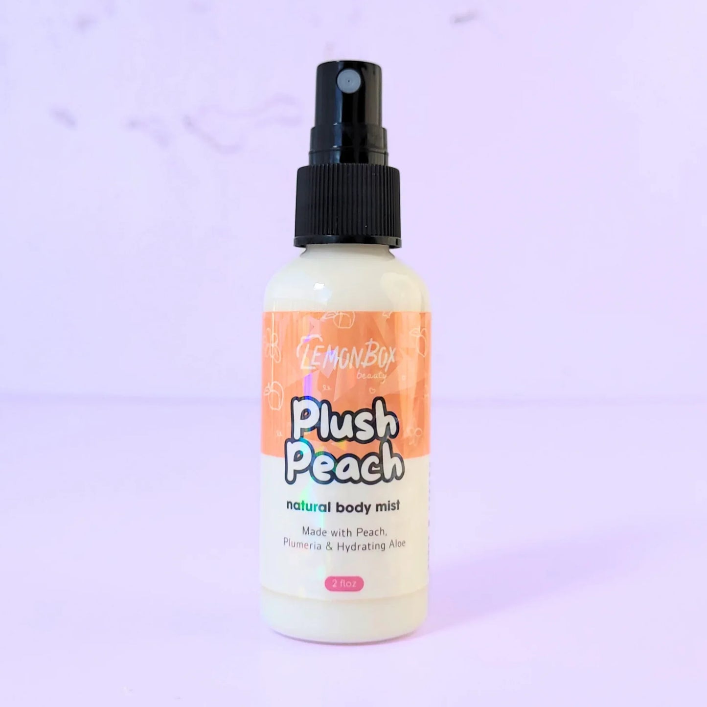 Lemon Box Beauty Peach Plush Natural Body Mist - clear spray bottle of soft peach and cream scented fragrance on a lavender background.