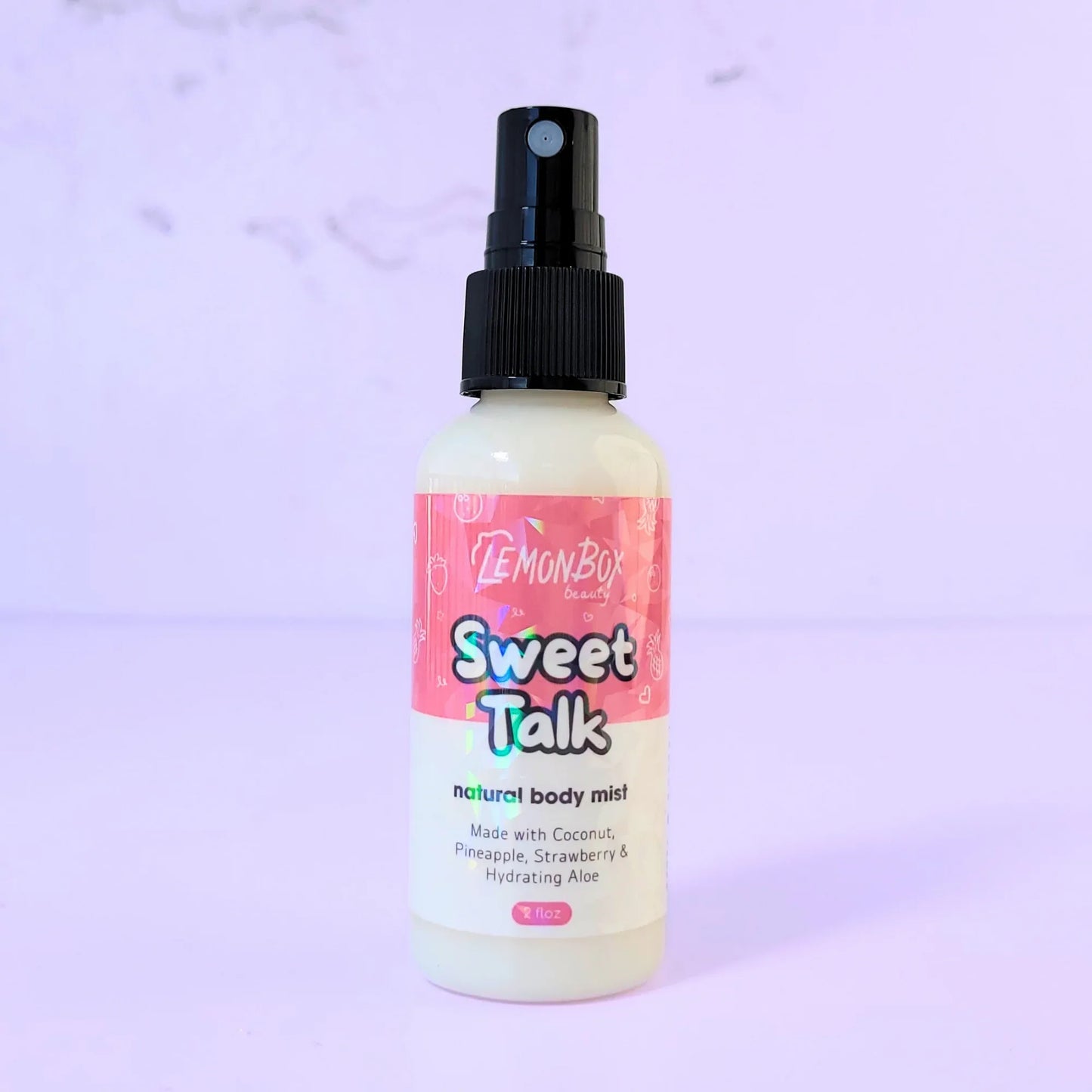 Lemon Box Beauty Sweet Talk Natural Body Mist - 2oz clear spray bottle of coconut, pineapple, and strawberry scented fragrance on a lavender background.