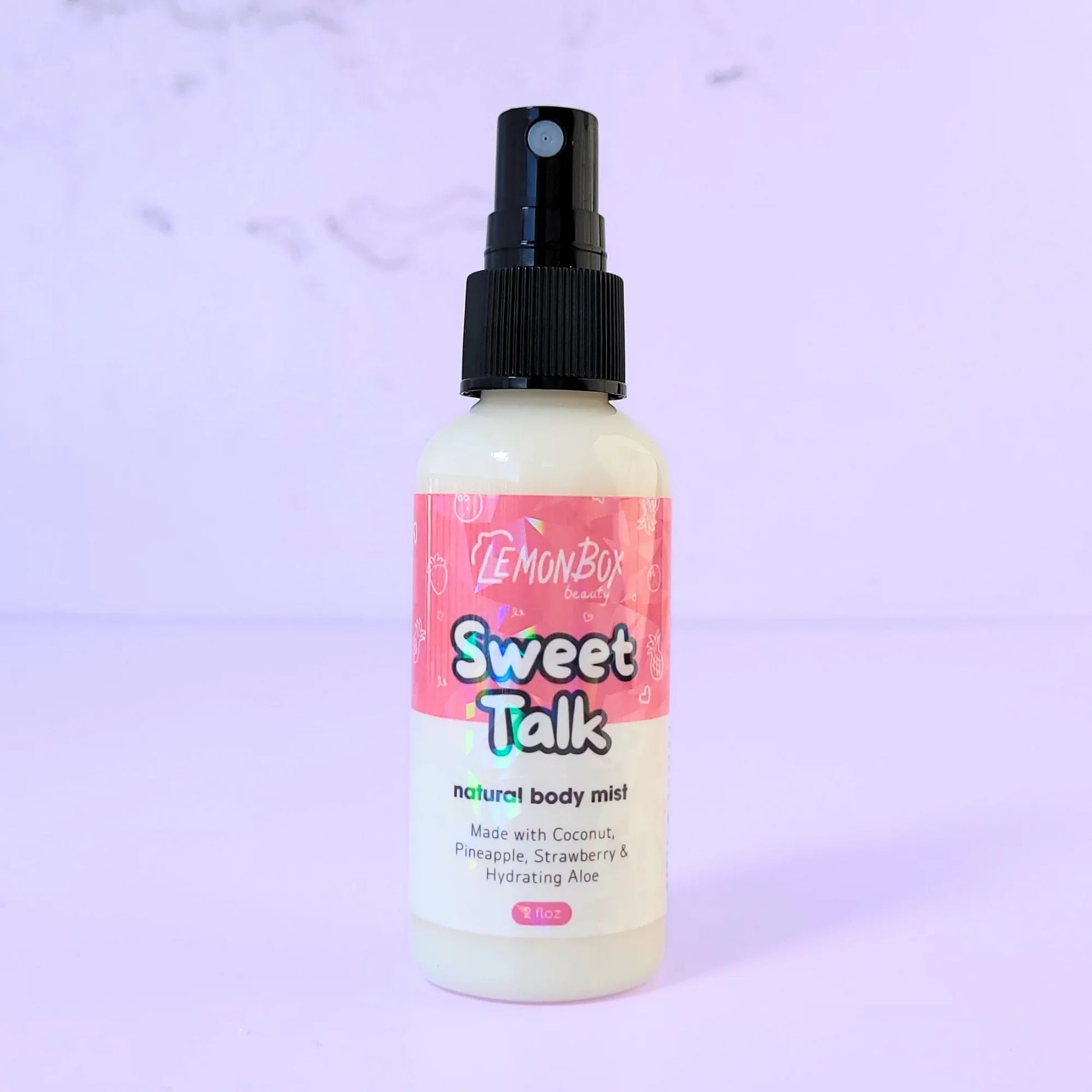 Lemon Box Beauty Sweet Talk Natural Body Mist - 2oz clear spray bottle of coconut, pineapple, and strawberry scented fragrance on a lavender background.