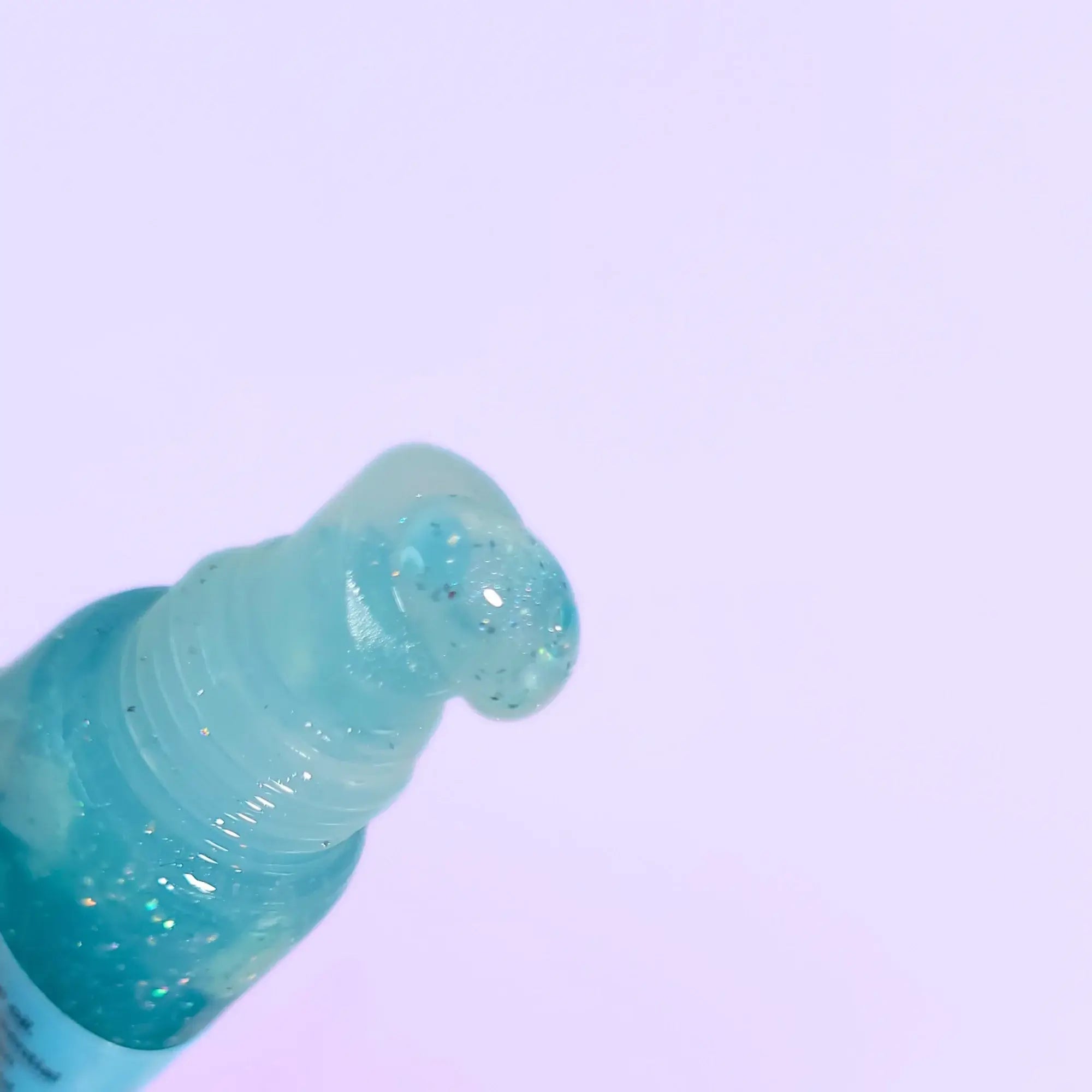 Close-up of a blue bottle cap on a light purple background