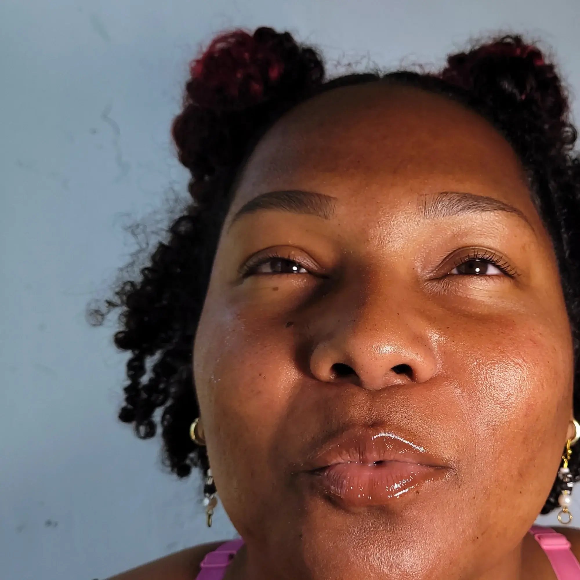 Close-up of a woman with styled hair against a light blue background